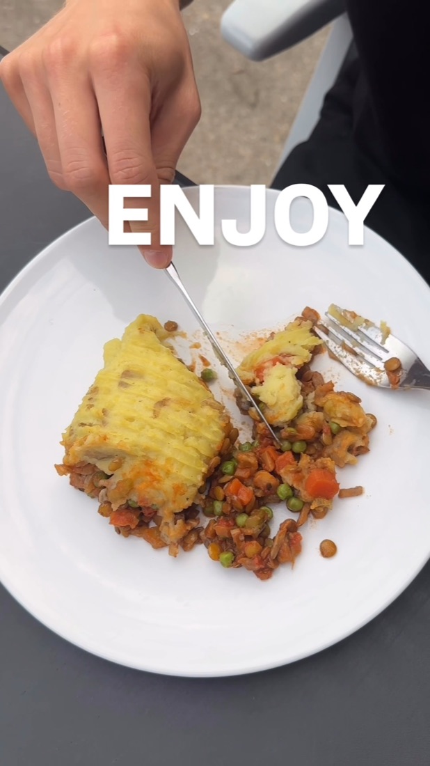 A plate of plant-based cottage pie with lentils and peas.